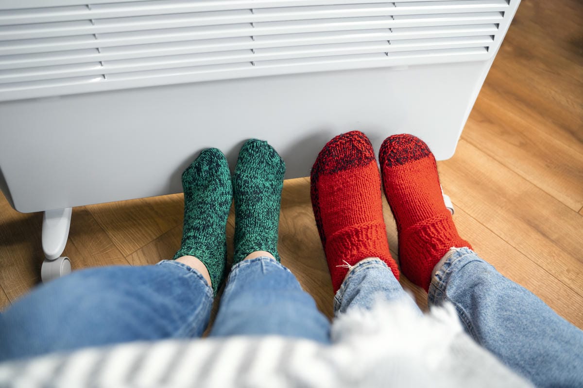 gros plan personnes avec jambes pres du radiateur maison 1