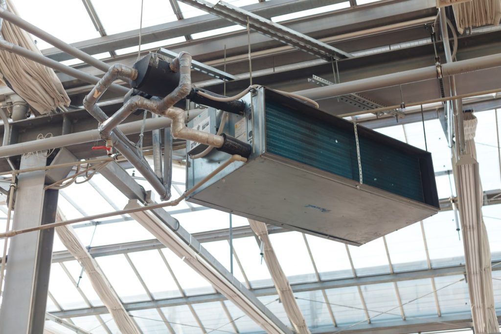 Aérotherme : comment ça marche et comment bien le choisir 3 Appareil de chauffage à air pulsé suspendu sous la verrière d'un grand local