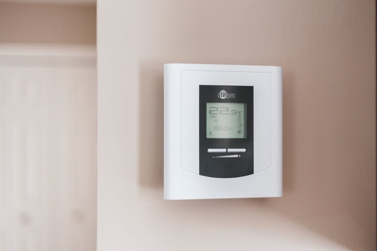 Thermostat d'ambiance mural affichant 22,5 °C mesurés et 18 °C de consigne