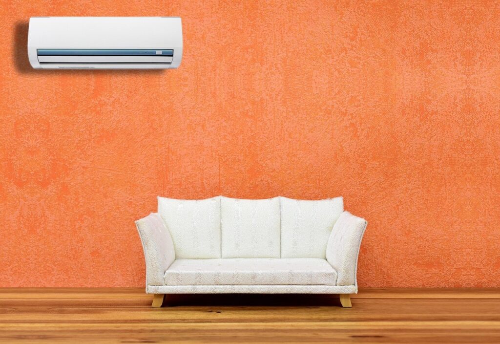 Climatiseur mural fixe installé au-dessus d'un canapé dans un salon