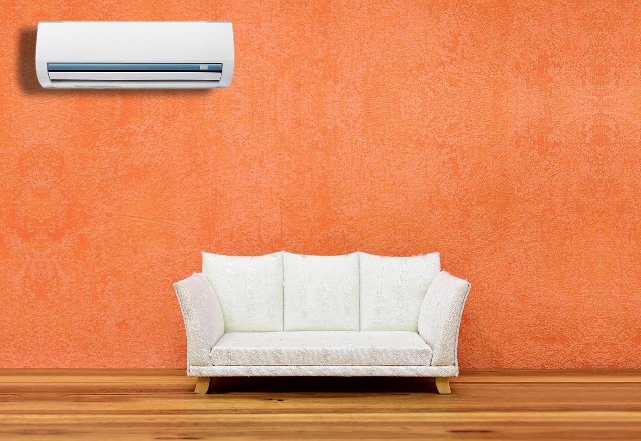 Climatiseur mobile ou fixe : quel est le vrai coût ? 2 Climatiseur mural fixe installé au-dessus d'un canapé dans un salon