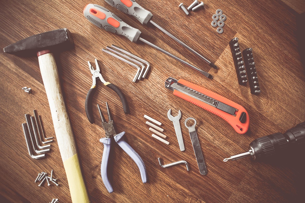 Climatiseur mobile mono-tuyau ou double tuyau : le bricolage qui limite la dépression 4 Outils de bricolage disposés sur un établi pour un montage fait maison