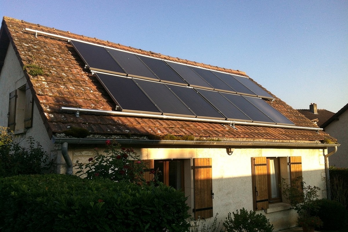 Capteurs solaires thermiques sur le toit de tuiles d'une maison