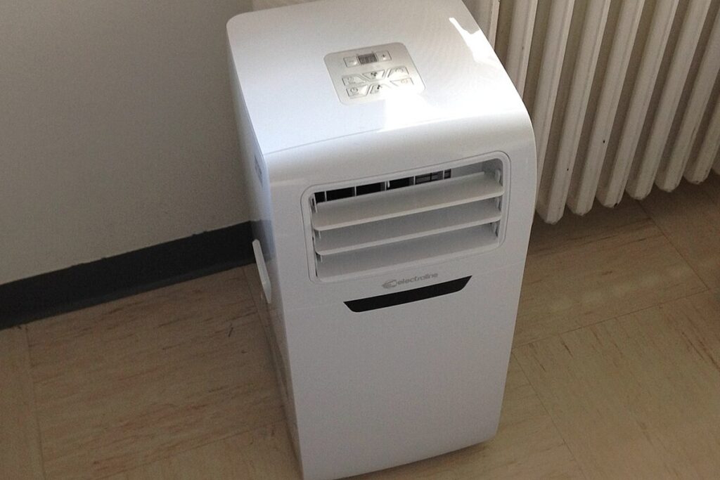 Climatiseur mobile : ce qu'il vaut vraiment (3 défauts physiques) 3 Climatiseur mobile blanc posé au sol contre un radiateur