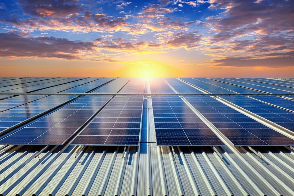 Champ de panneaux solaires sur toiture métallique au coucher du soleil