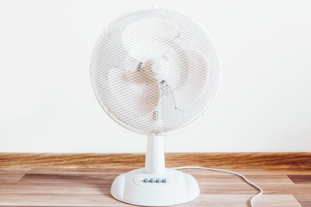 Ventilateur : 5 idées reçues qui vous font transpirer pour rien 8 Ventilateur de table blanc posé sur un parquet clair
