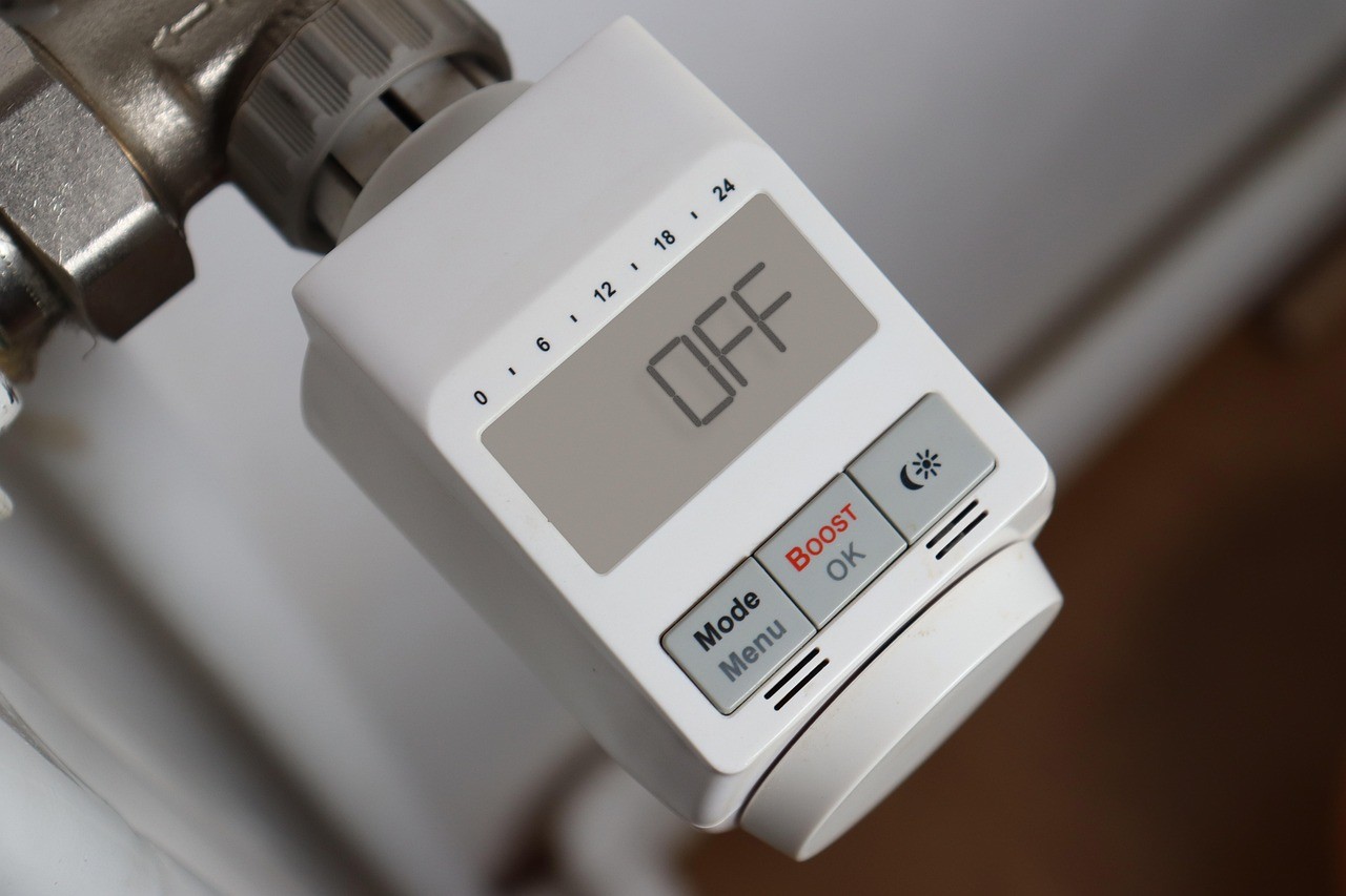 Thermostat de radiateur numérique générique affichant un mode arrêt, fixé sur une vanne de chauffage